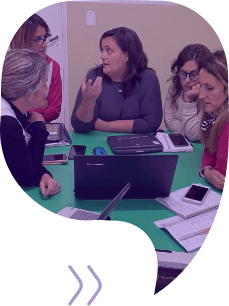 Fotografía de docentes mujeres, reunidas junto a una computadora.