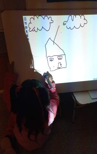 Un estudiante dibujando en la pizarra interactiva.